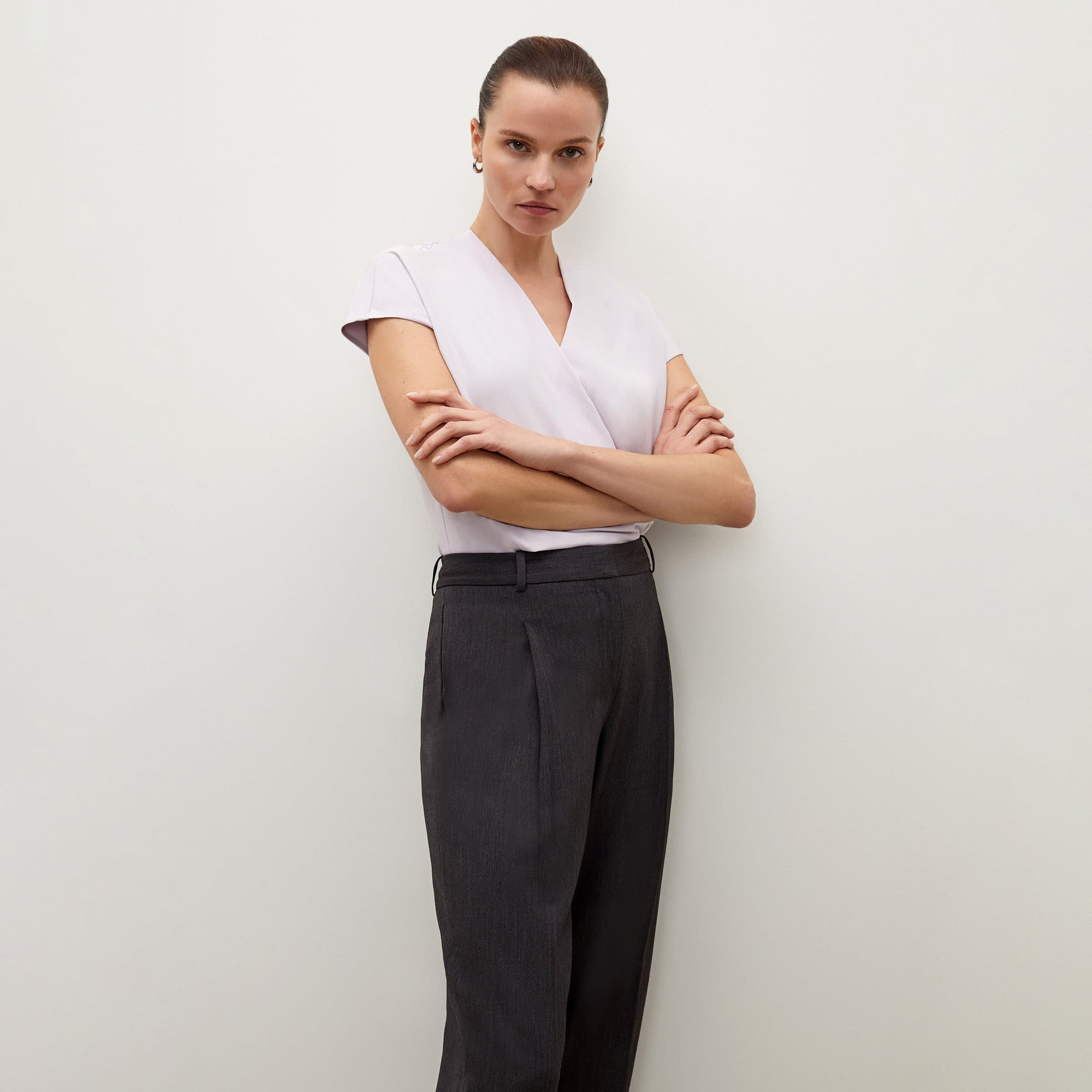 Side image of a woman standing wearing the Isadora pant in charcoal
