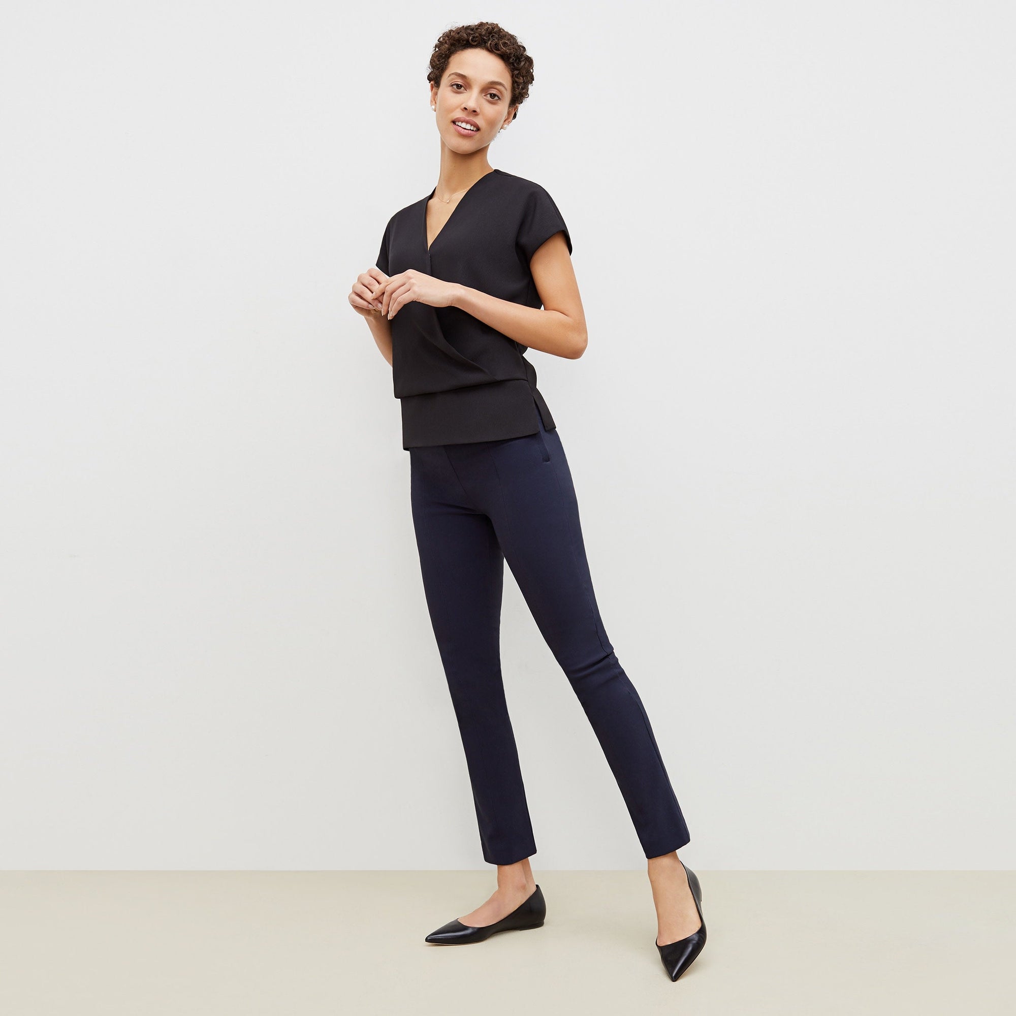 Front image of a woman standing wearing the foster pant in dark navy | Exclude