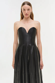 Black leather strapless bustier gown with sweetheart neckline and pleated full skirt.
