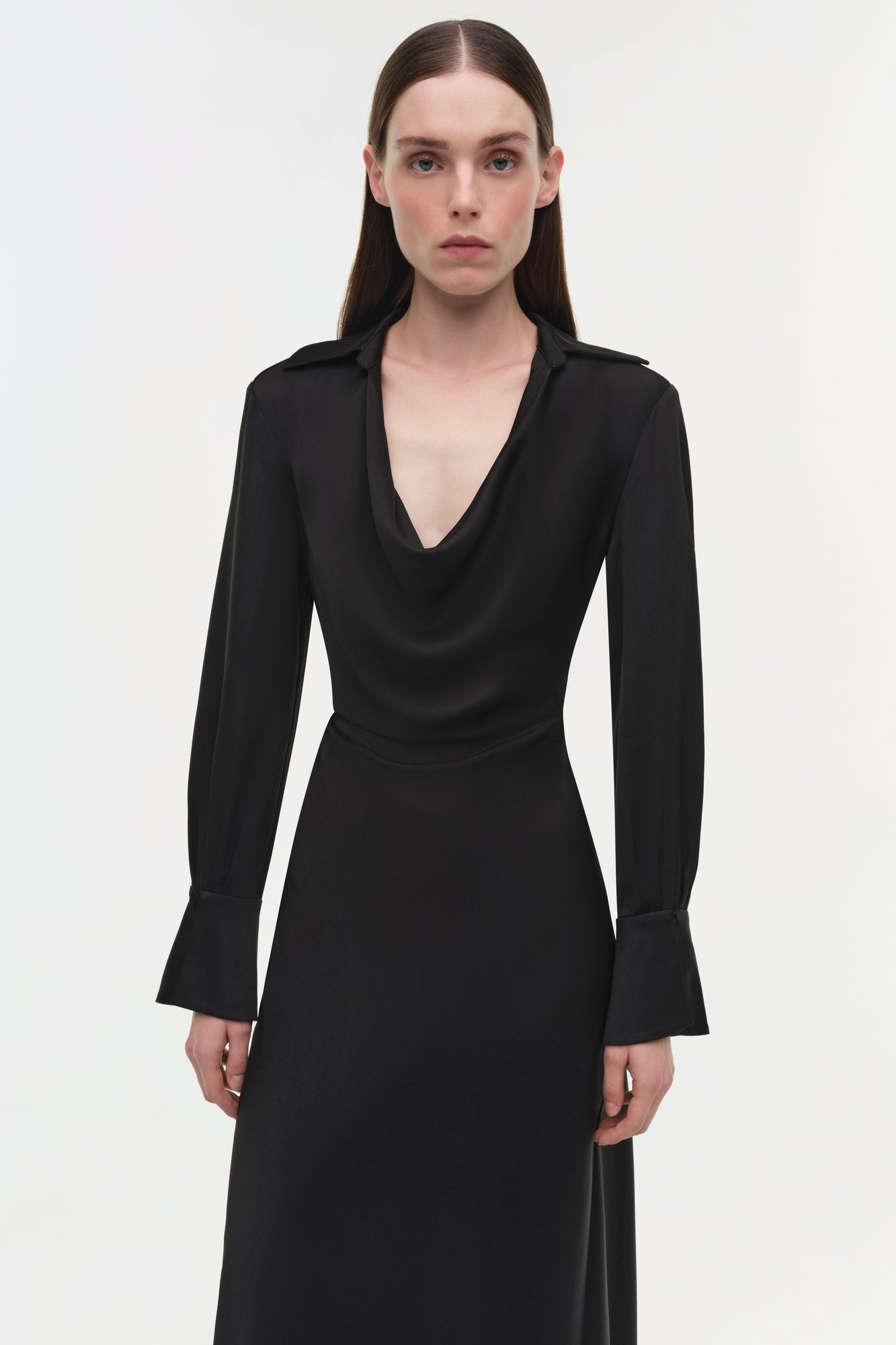 Black satin gown with draped cowl neckline, long bell sleeves, and fitted waist.