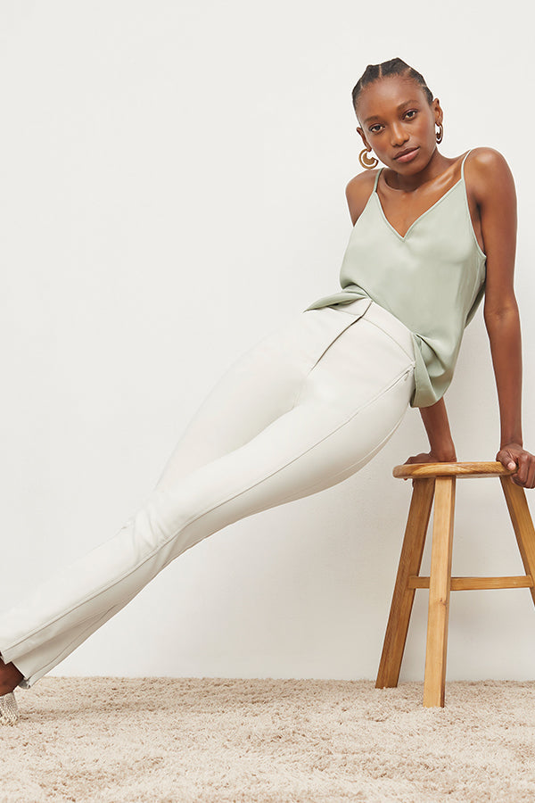 Front image of a woman standing wearing the Curie Pant—Everstretch in Bone | Exclude