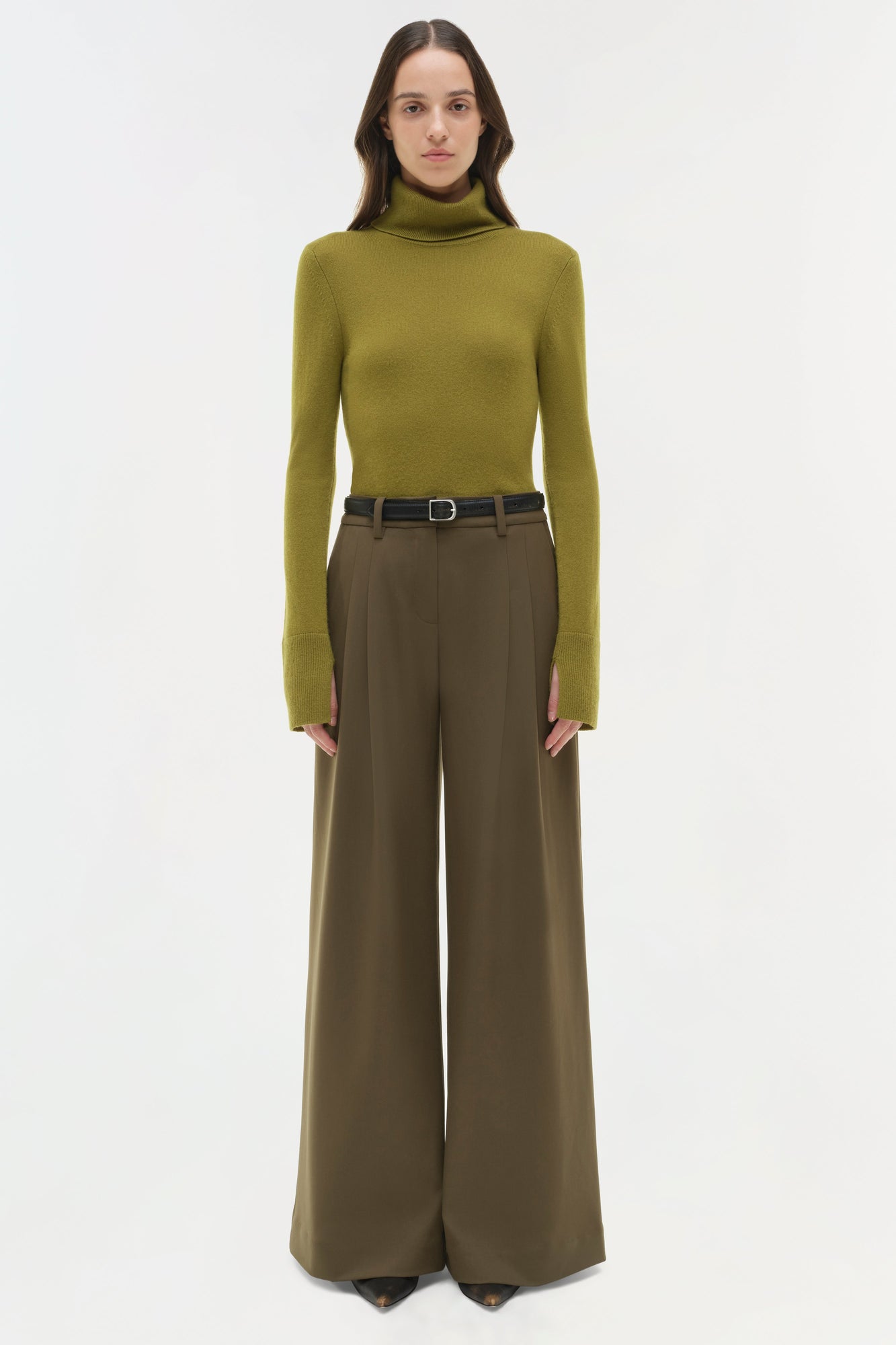 Olive wide-leg pant with pleated front waistband and black belt, styled with olive turtleneck.
