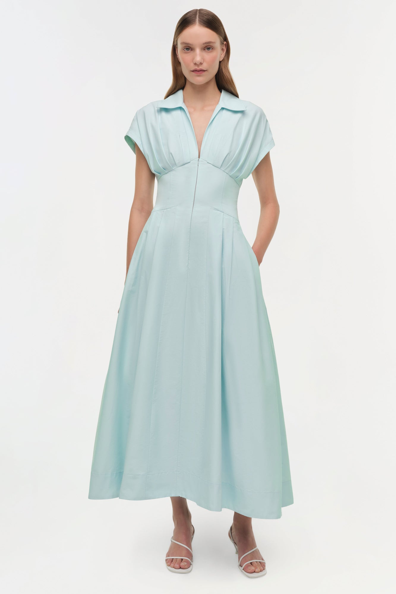 Light blue midi dress with short sleeves, collared neckline, fitted bodice, and full skirt with side pockets.