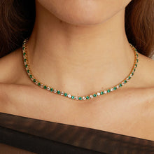 Model. Necklace with green gemstones worn by a person