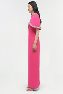 Hot pink floor-length gown with draped cape overlay and crystal-embellished neckline and hem.