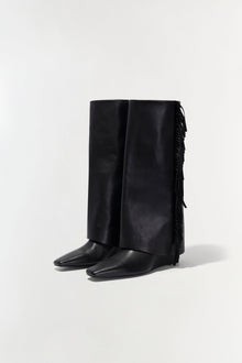 Black leather knee-high boot with fringe trim along the back shaft and pointed toe.
