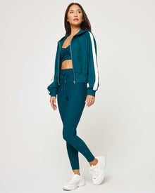 Side view of model wearing the Back To Back Jacket in deep teal-cream with matching deep teal-cream Back To Back Pant.