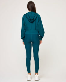 Back view of model wearing the Back To Back Jacket in deep teal-cream showing the cream contrast back panel, with matching deep teal-cream Back To Back Pant.