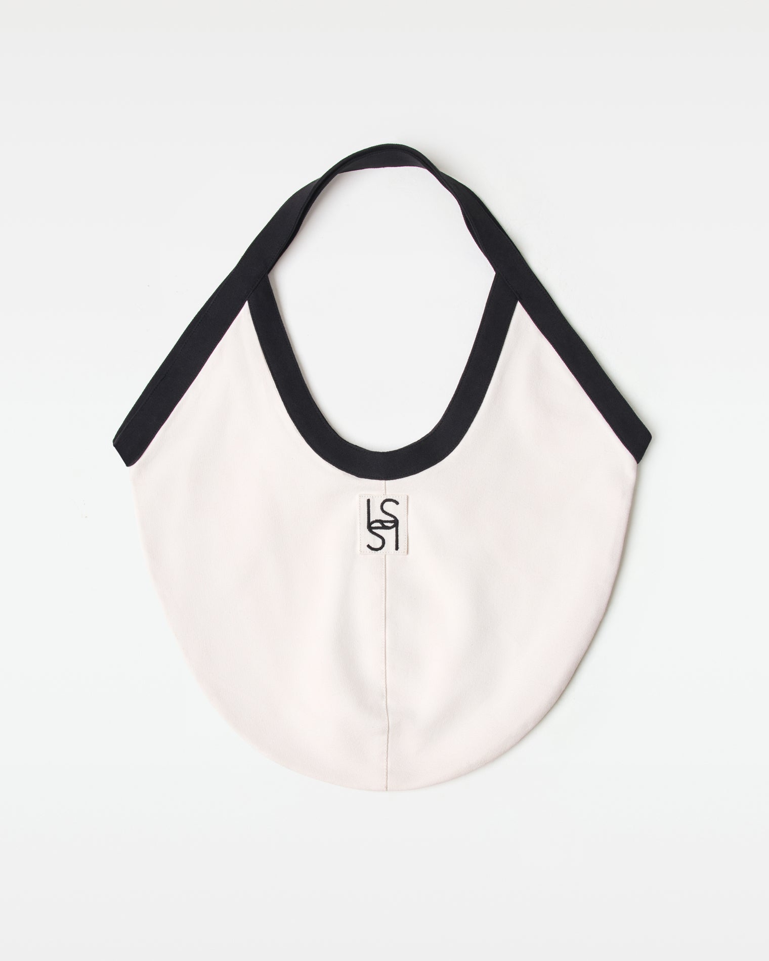Off-model back view of the black and cream Bronte Canvas Bag showing a L*SPACE logo.