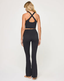 Back view of model wearing the Declan Legging in black with black crossback crop top.