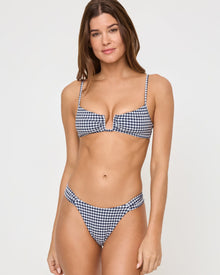 front view of woman wearing blue and white gingham bikini in front of a white background