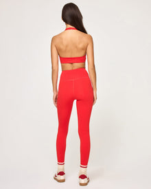Back view of model wearing the Jeanne Bra in flame showing the open halter back, with matching flame Level Up Legging.