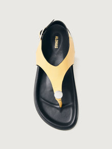 Buttery yellow colored sandal with black sole and silver hardware. 
