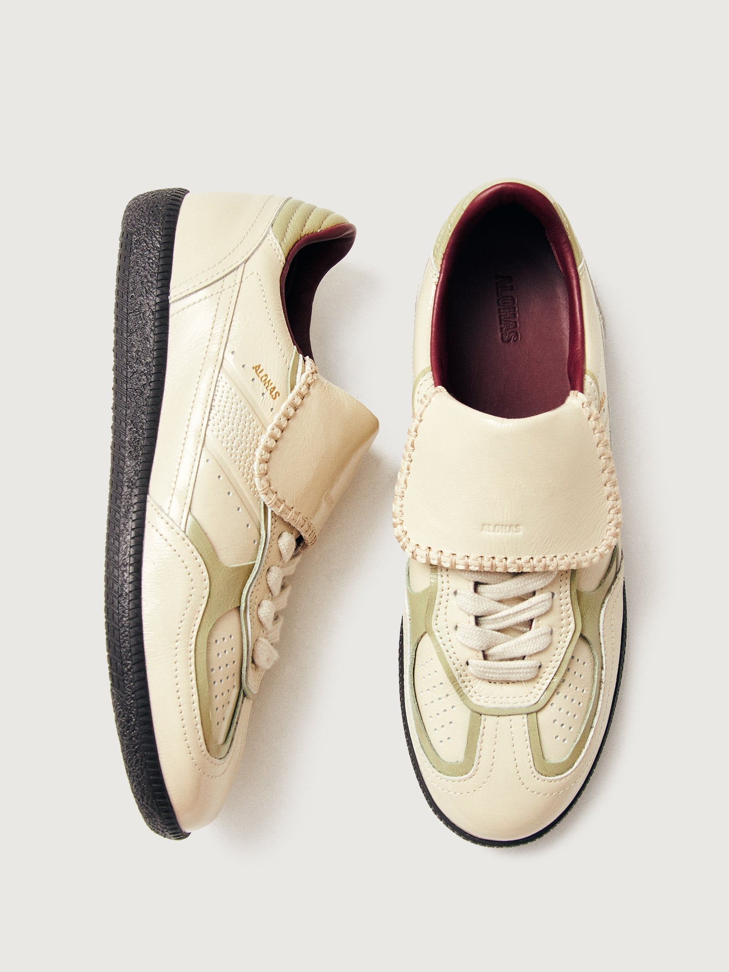 Creme colored low top lifestyle sneaker with black sole & gold/creme heel detailing. 