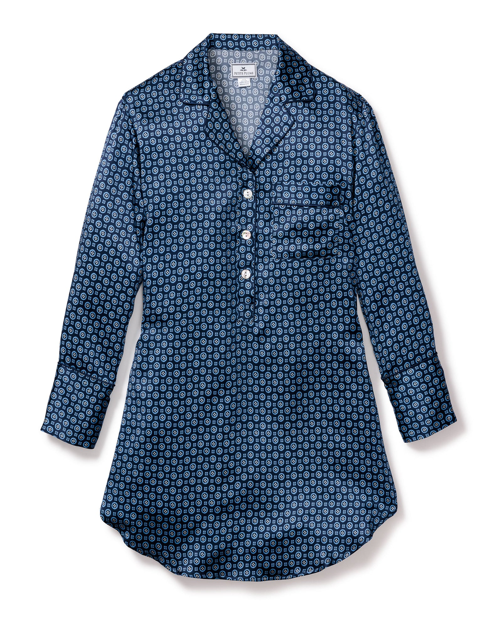 The Womens Silk Nightshirt in Midnight Foulard by Petite Plume is a perfect nightshirt. It boasts a blue patterned design with circular shapes in various shades of blue and white, a half-button placket with four buttons, and a single chest pocket.