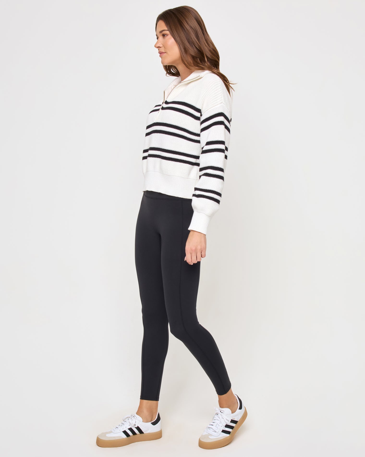 Side view of the LSPACE Ultra Stripe Sweater in black-white on a model, showing the profile and ribbed texture of the black and white striped sweater.