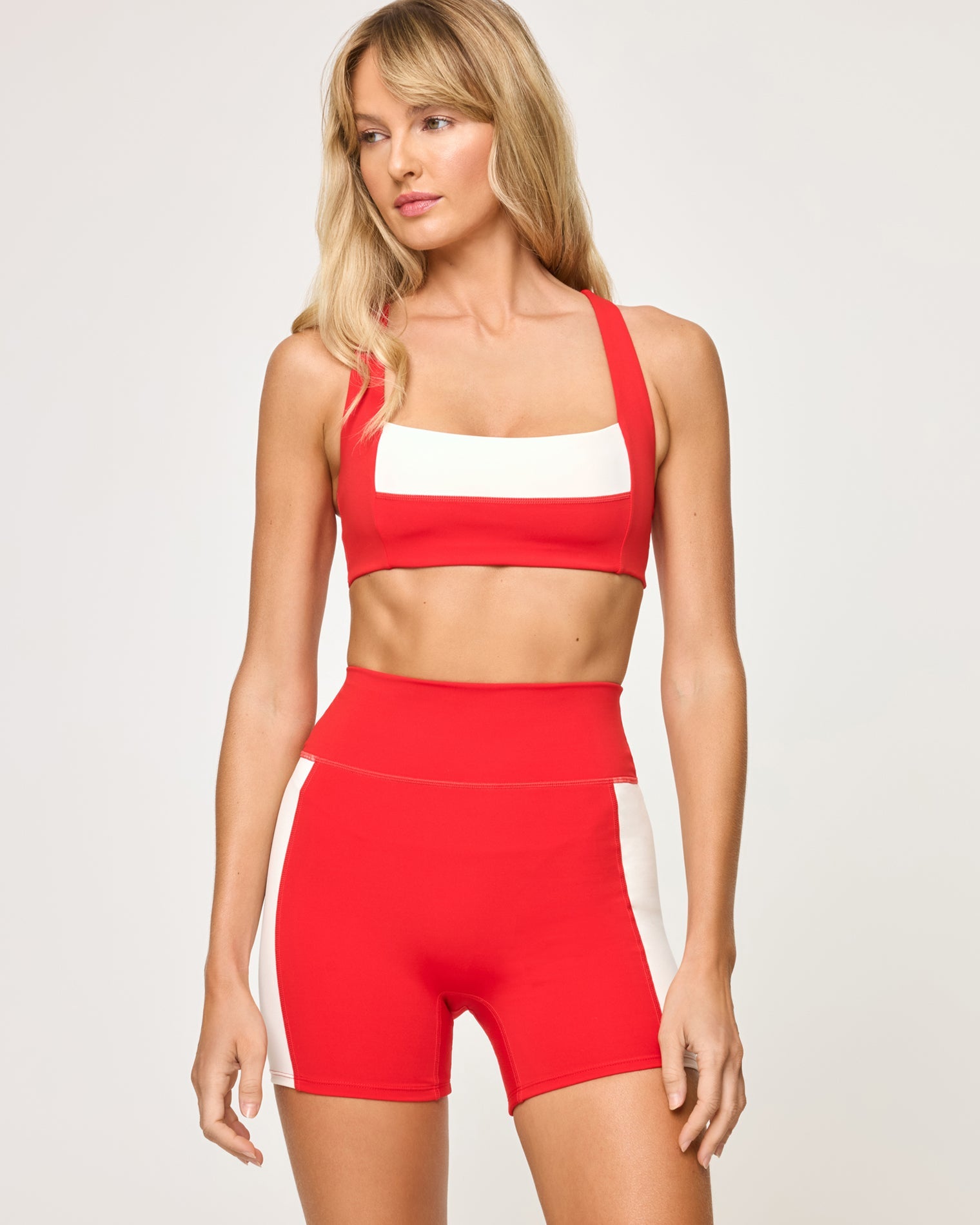 Close-up front view from the waist down of the LSPACE Uppercut Short in flame-cream on a model, highlighting the high-rise waistband and cream trim detail of the active shorts.