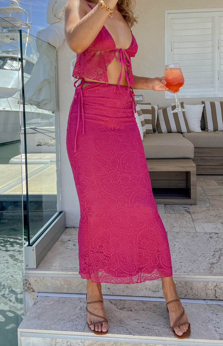 Rear-side view of a fuschia lace maxi skirt with adjustable tie-up sides and a subtle paisley pattern
