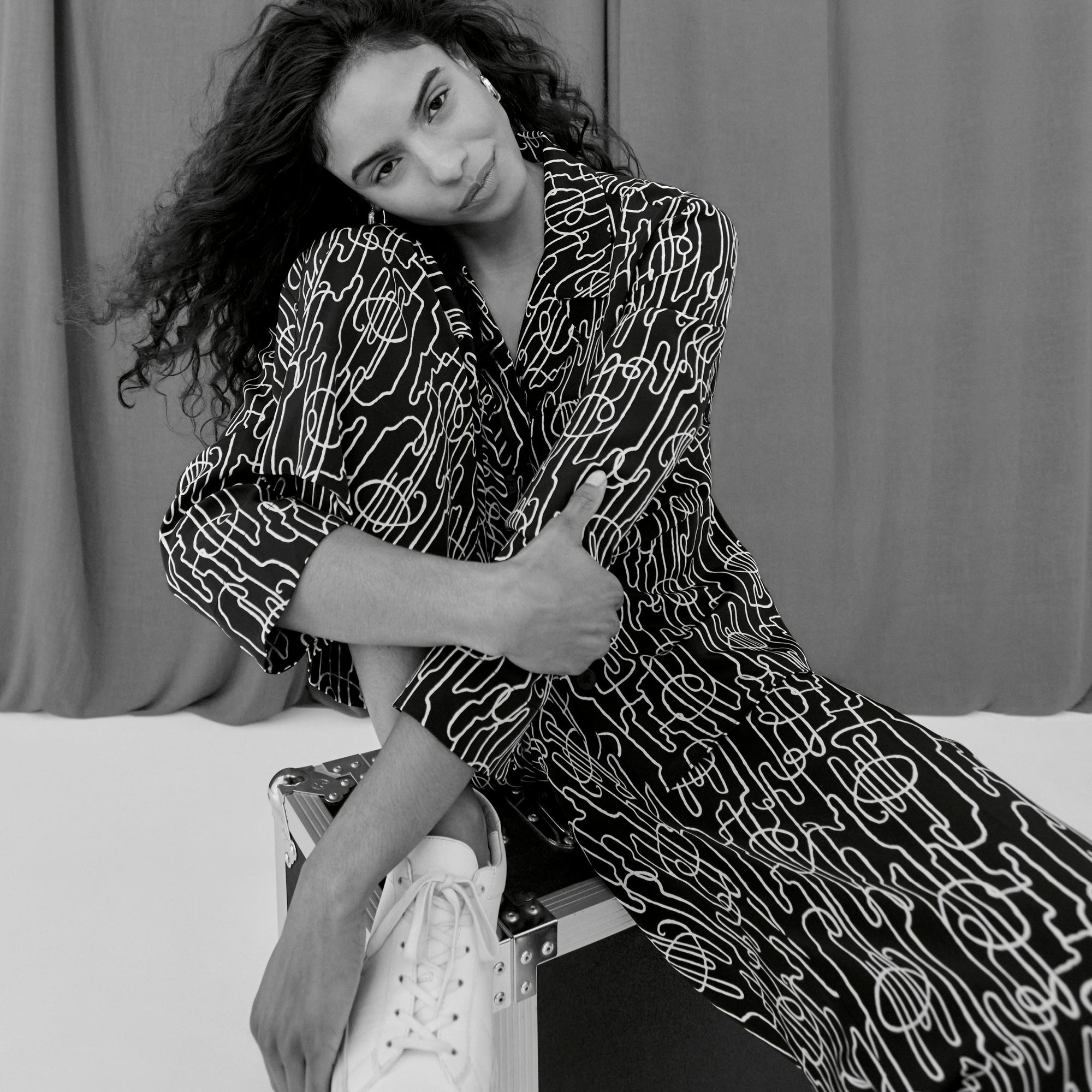 image of a woman sitting wearing the alyssa jacket in symphony print | ALT GRID