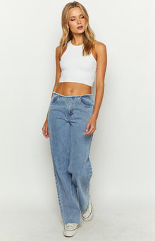 Front view of mid wash blue denim jeans with a mid rise and wide leg, featuring a frayed waistband and hem