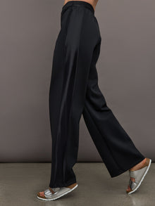 Model wears black wide leg pants with an elastic waistband. 