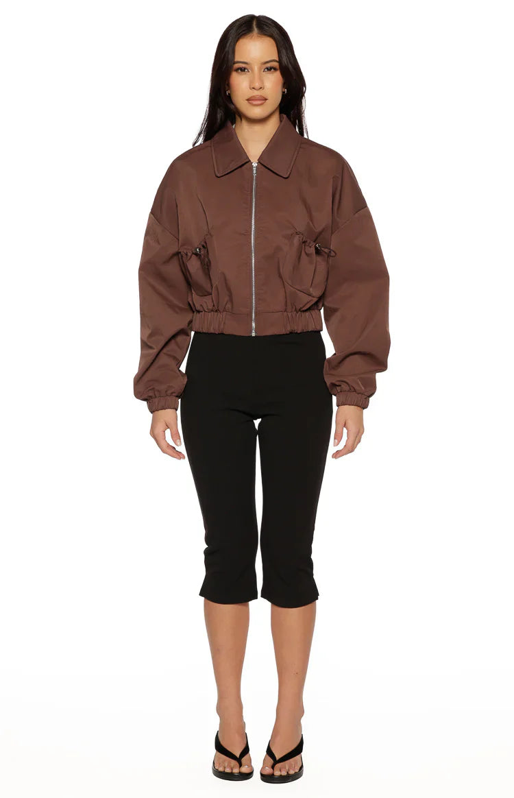 Front view of a chocolate cropped bomber jacket with a collar, zip, and gathered drawstring details