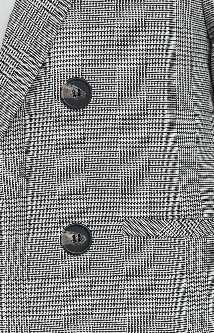 Black and white glen check blazer with two dark buttons, a notched lapel, and a flap pocket