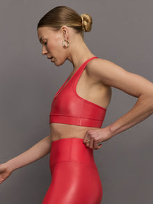 Model wears a v neck bright red bra in a liquidy takara shine finish. 