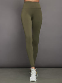 Model wears full-length olive leggings with a high-rise wide waistband and smooth, compressive fabric.