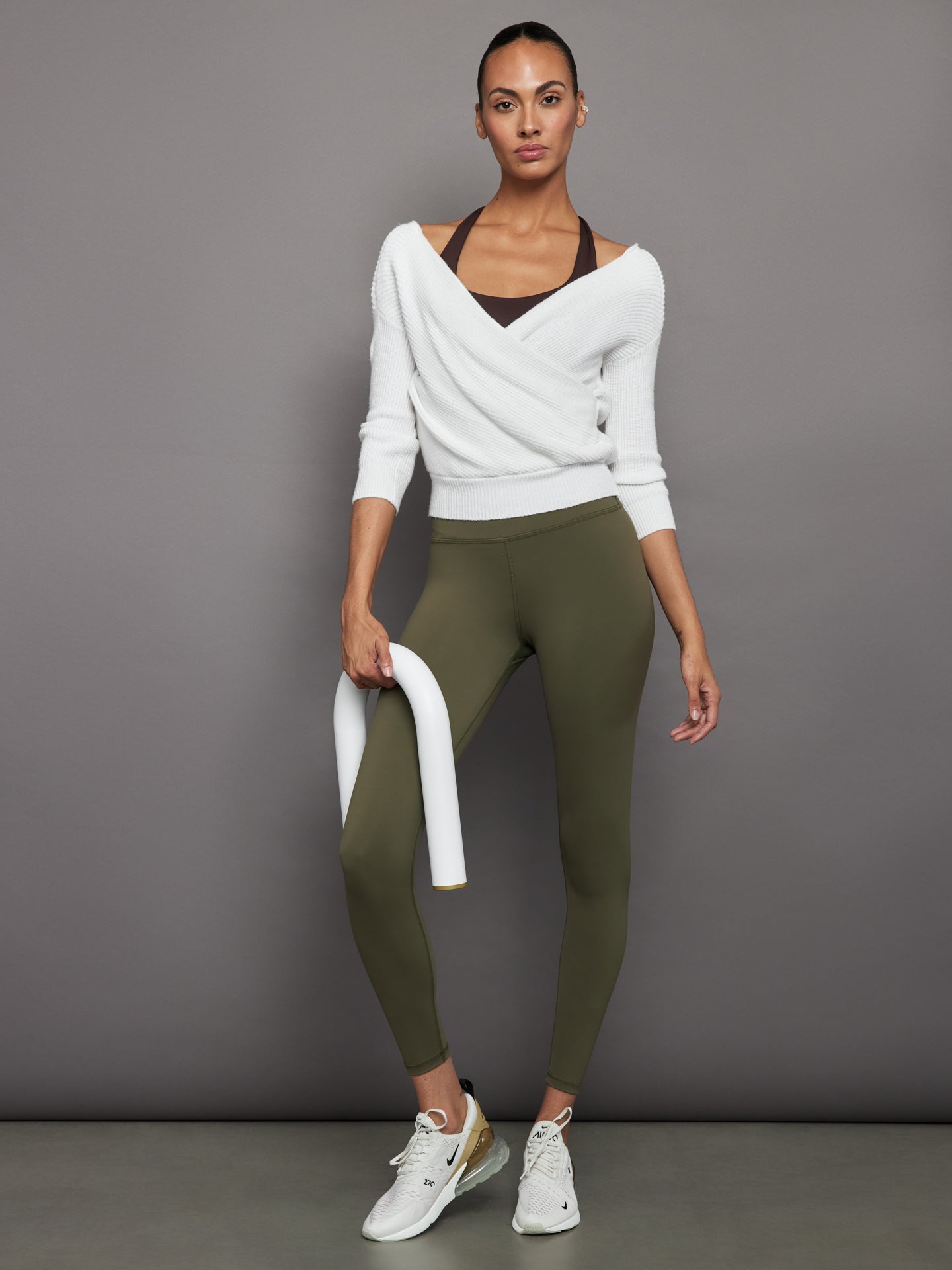 Model wears full-length olive leggings with a high-rise wide waistband and smooth, compressive fabric.