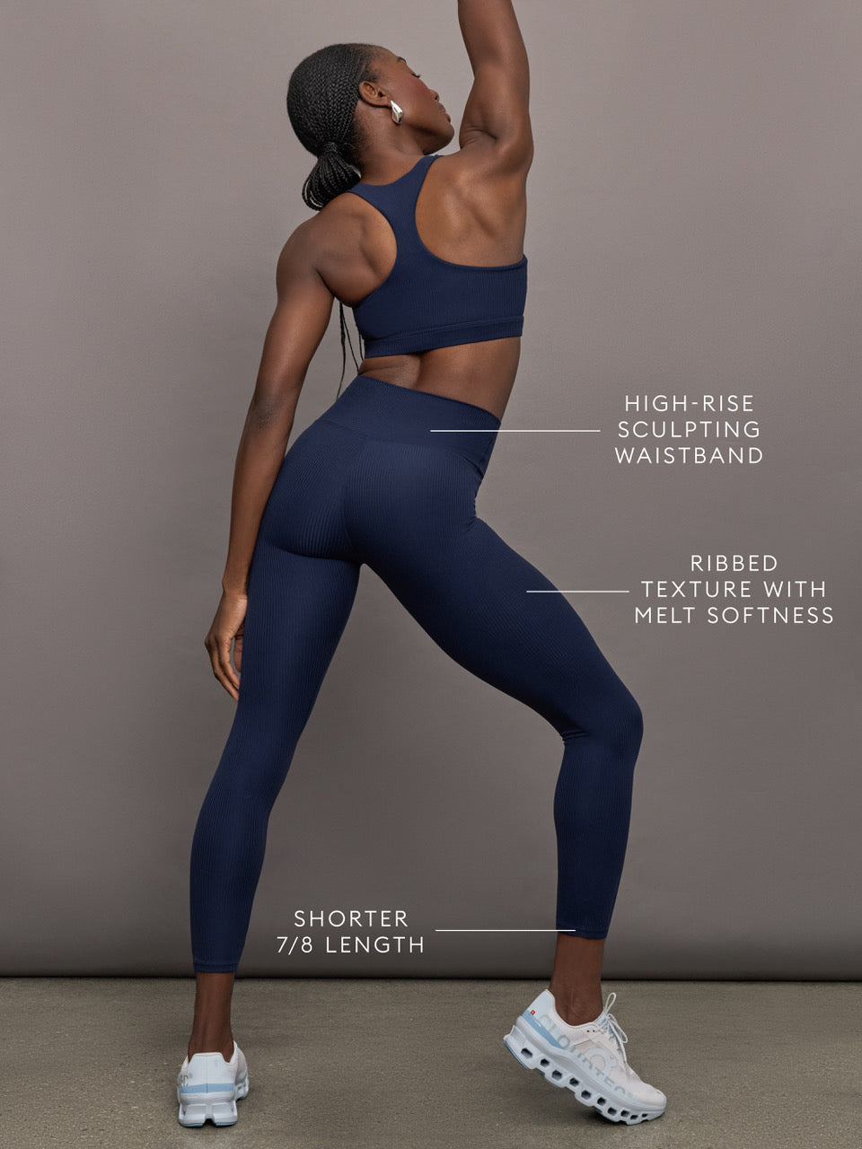 Model wears navy, high-rise leggings with a ribbed texture and a smooth, form-fitting silhouette.
