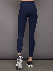 Model wears navy high-rise, full-length leggings with a matte finish and a smooth, body-hugging fit.
