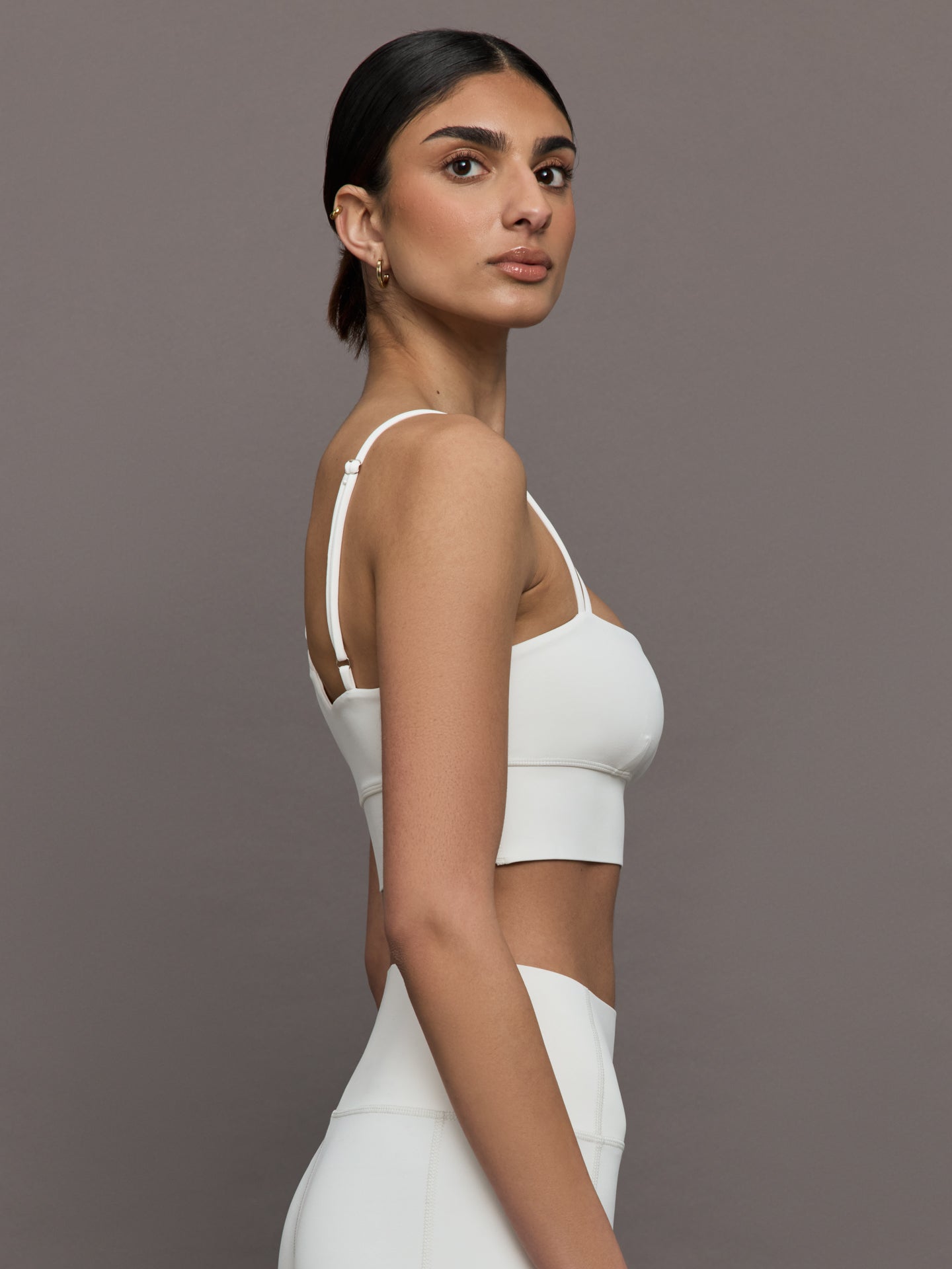 Side view of the Asymmetrical Strappy Bra in Diamond Compression Cloud Dancer showing the asymmetrical strap and sleek fit.
