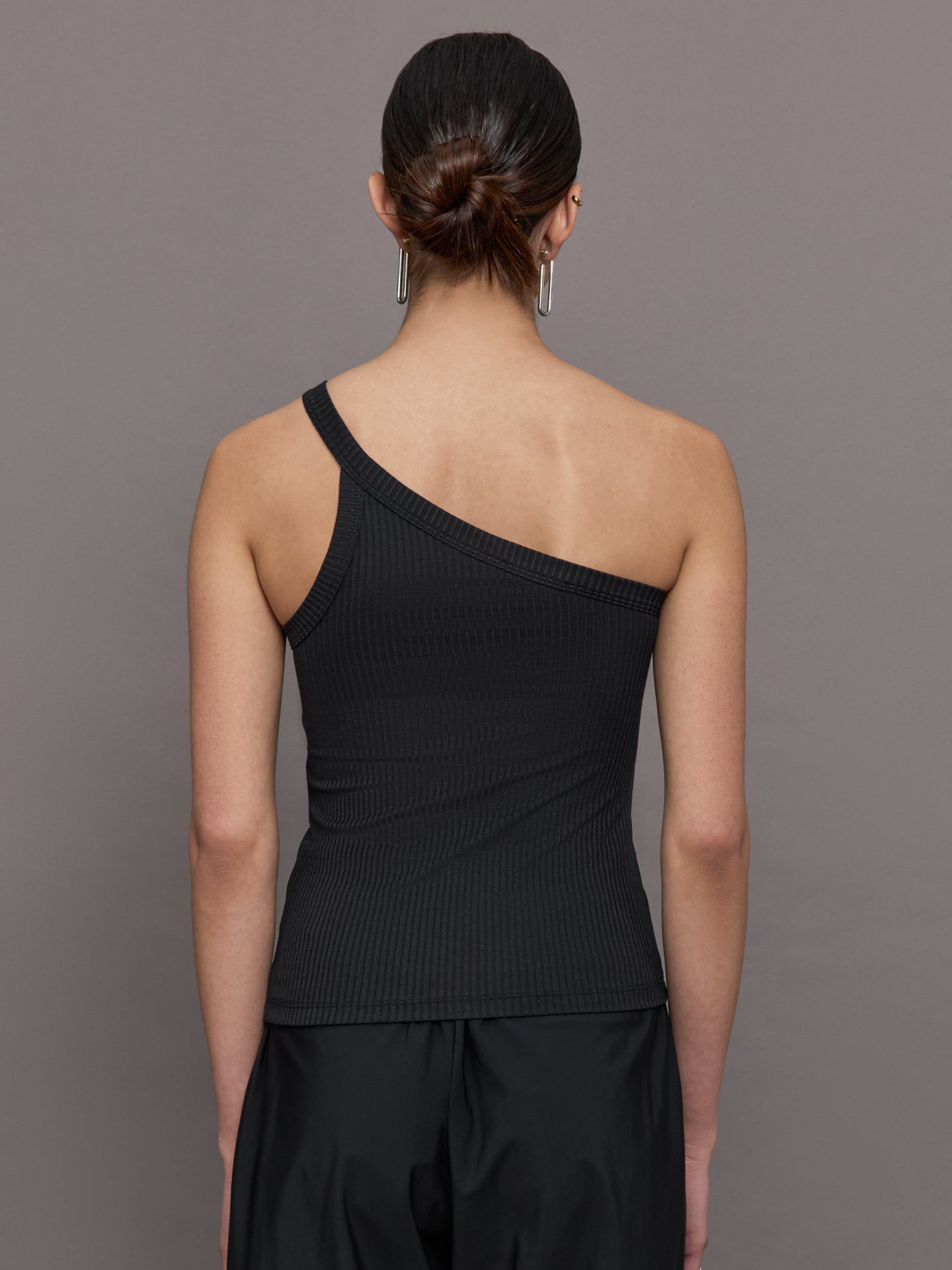 Model wears a black ribbed one shoulder tank.