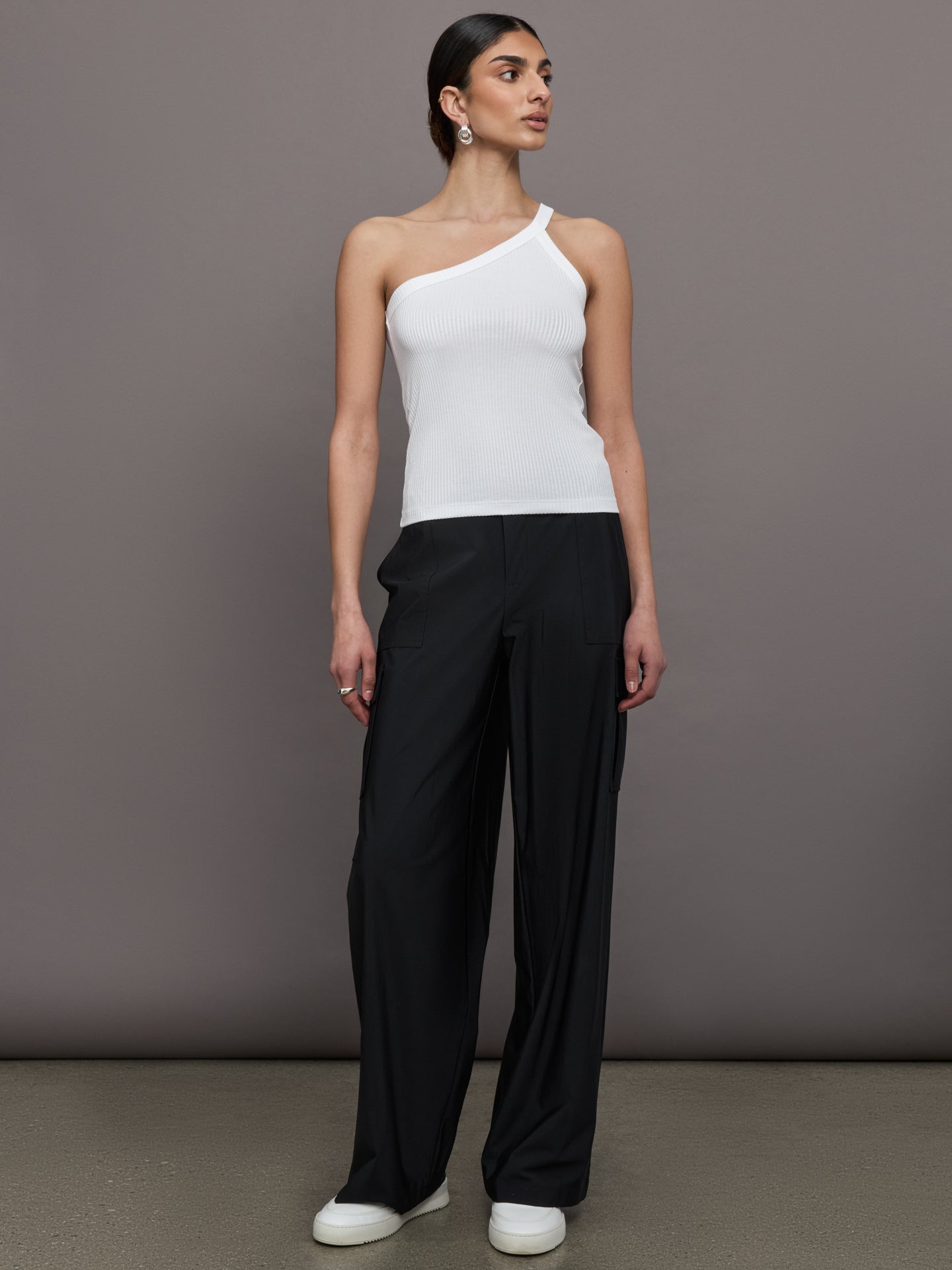 Model wears a white ribbed one shoulder tank.