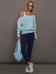 Model wears a light blue off shoulder french terry sweatshirt. 