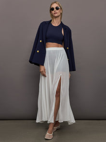 Full body view of model styled in Mesh Pleated Skirt Ivory with navy crop top and blazer.