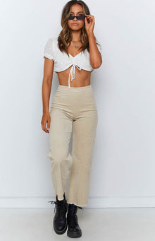 Beige corduroy wide leg pants with a high waist and frayed cropped hem