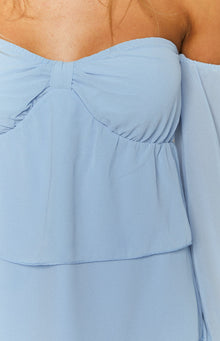 Close-up of the light blue off-shoulder mini dress bodice showing sweetheart neckline with bow detail and ruched waist