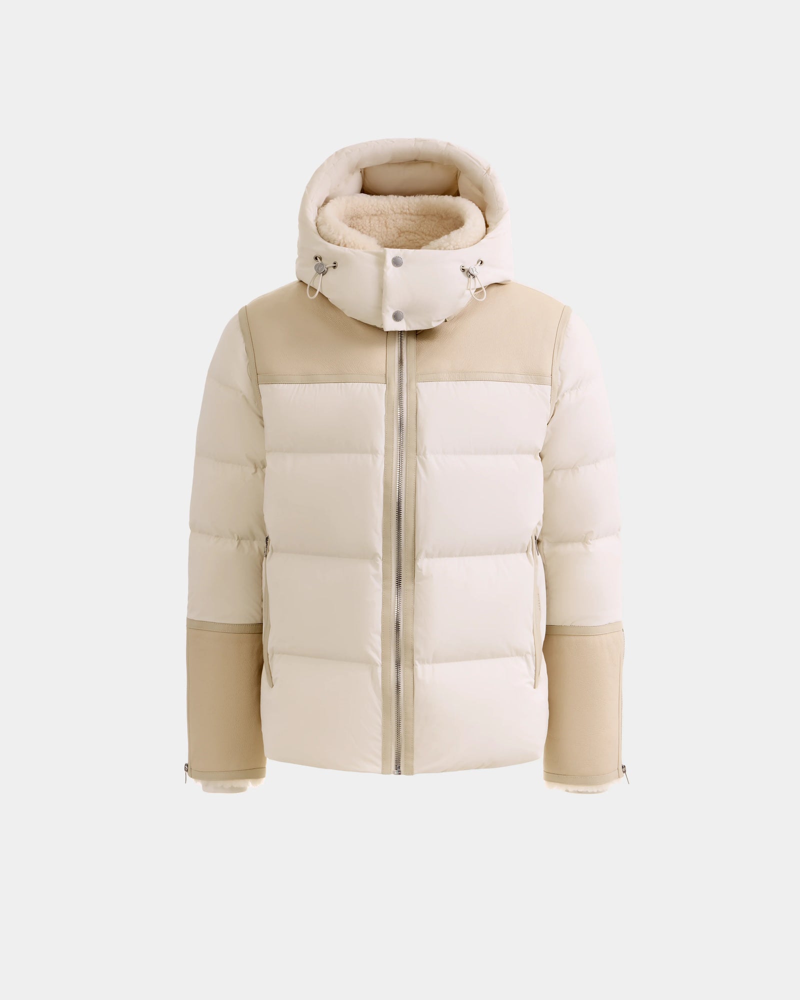 The DAVID - M125508 Vanilla by Rudsak is a men’s beige and cream shearling puffer jacket with a high collar, hood, zip closure, quilted panels, and beige sleeves. Shown insulated and warm against a white background.
