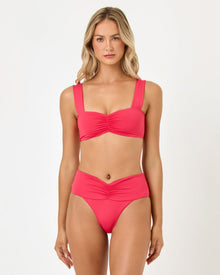 Woman wearing a pink bikini set on a white background