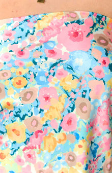 Close-up of the abstract floral print in pink, blue, yellow, peach, and brown on the mini dress fabric