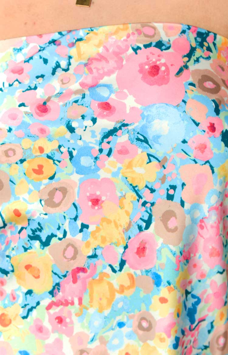 Close-up of the abstract floral print in pink, blue, yellow, peach, and brown on the mini dress fabric