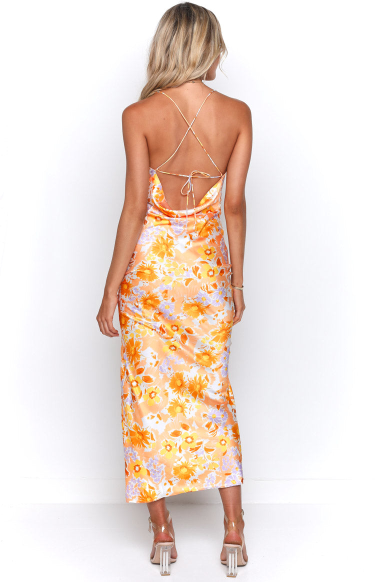 Rear view of an orange floral satin maxi dress with a low cowl back and criss-cross tie straps