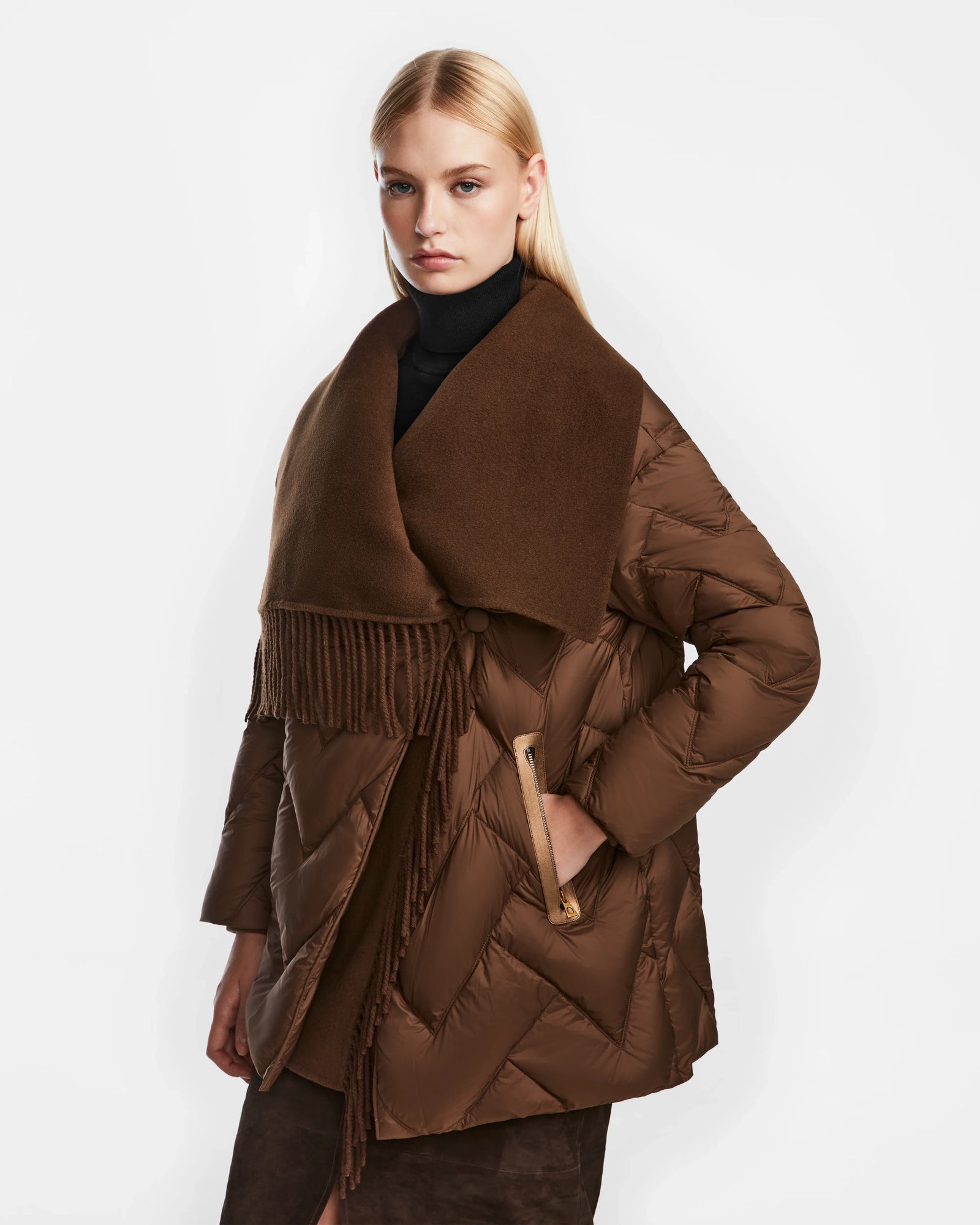 A woman with straight blonde hair wears the Rudsak ANNE MARIE - 8124713 Mocha mid-length quilted down wool jacket with a large scarf collar and black turtleneck, posing against a plain white background.