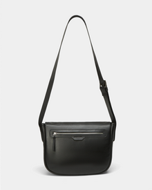 The GRAYSON - 8324512 Black by Rudsak is a black leather crossbody bag featuring a long adjustable shoulder strap, front zippered pocket, and minimalist design, shown against a plain white background.