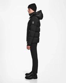 A person in profile against a white background wears the Rudsak JACK - M124507 Black winter jacket, paired with a black beanie, pants, and boots.