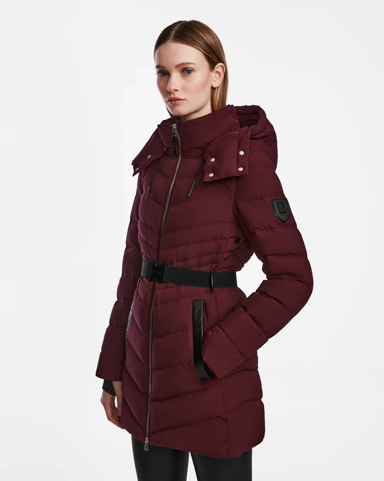 A woman wearing the Rudsak MALAYA M - L123554 Wine women’s down puffer jacket with herringbone quilting.