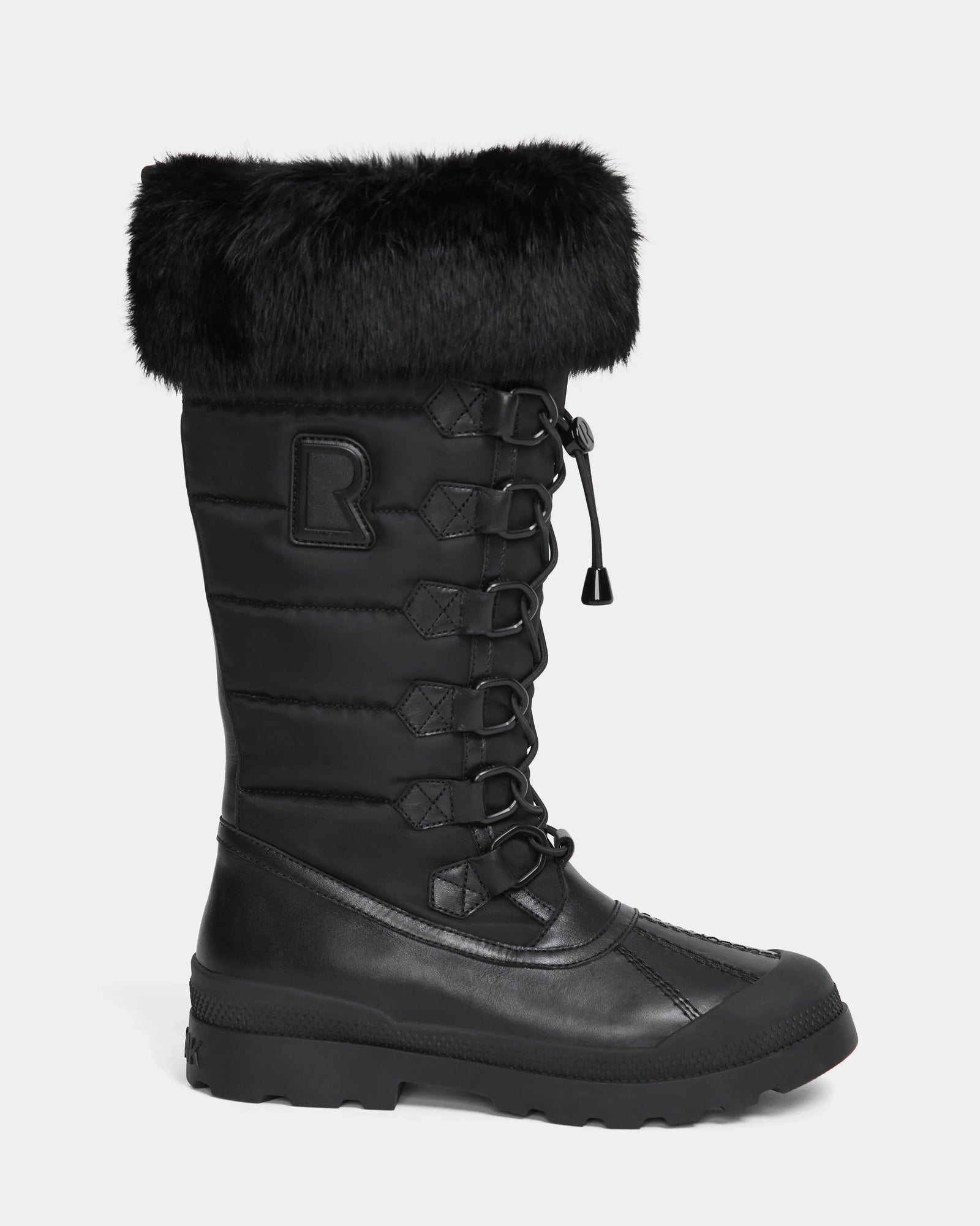 The WINDY - L224507 Black by Rudsak is a tall women's winter boot with cold-weather comfort, faux fur trim, lace-up front, quilted shaft, signature R patch on the side, and a sturdy rubber sole.