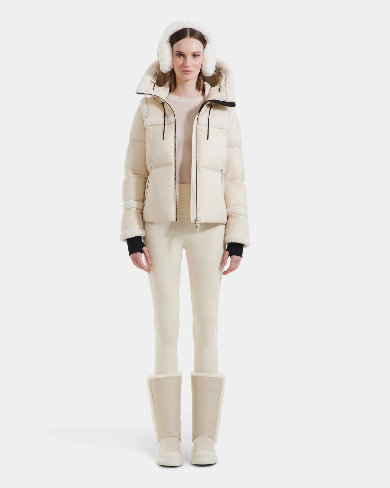 A woman showcases a chic and cozy winter look in the Rudsak JULIANA - L124509 Vanilla coat and white pants.